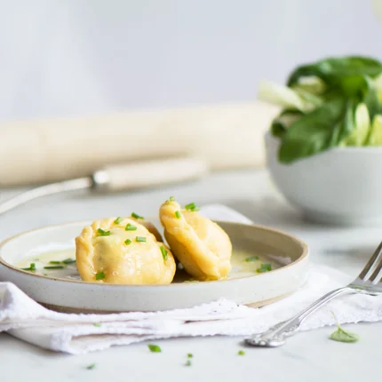 Twee gevulde deegkussentjes met saus op een bord
