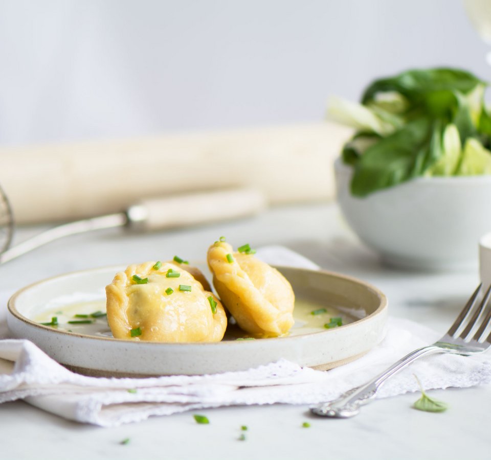 Two stuffed dumplings with sauce on a plate