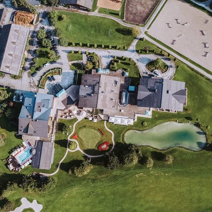 Aerial view of a large building complex with pond and landscaped gardens