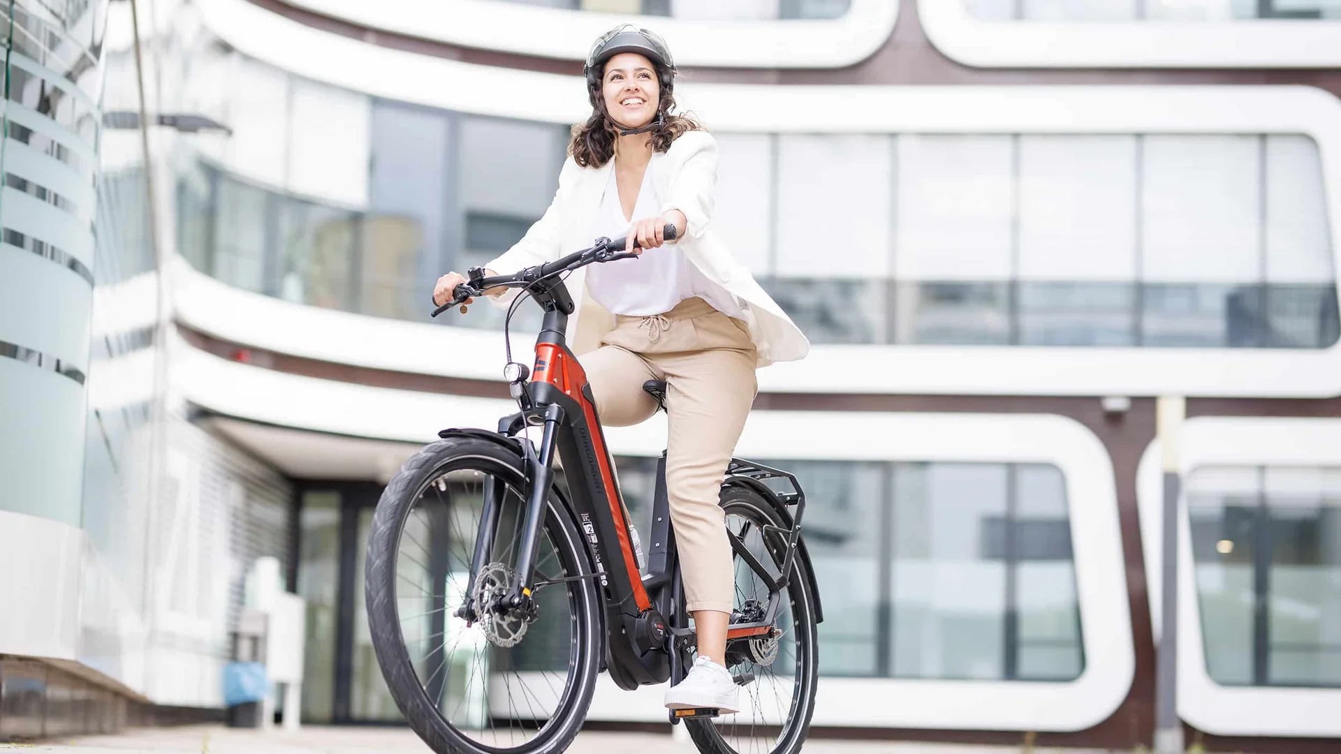 Schwalbe © Ralf Bohle GmbH Vrouw rijdt een moderne elektrische fiets met helm in de stad
