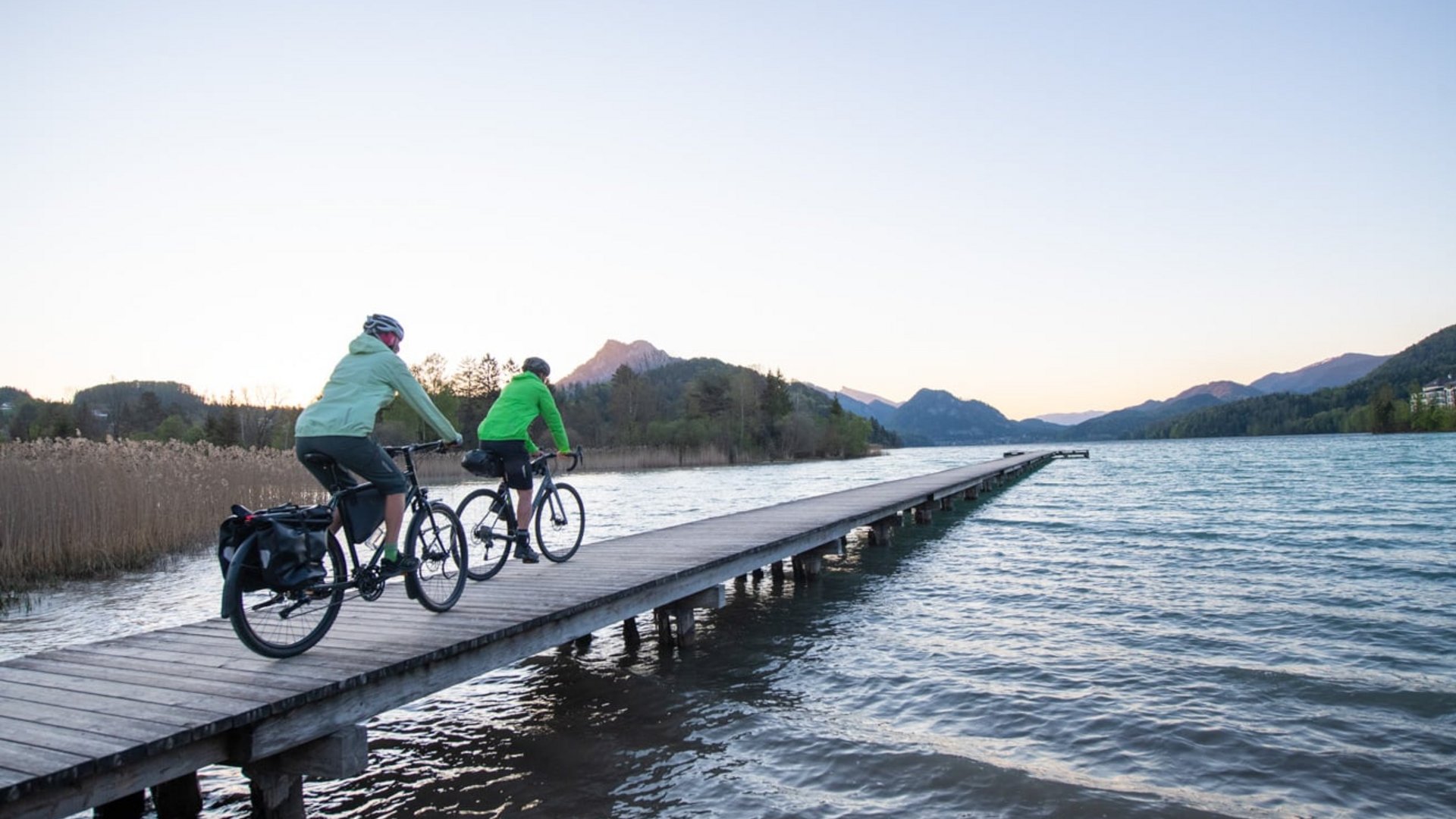 Schöffel © Zooom.at Two cyclists on a pier by the lake with mountains in the background