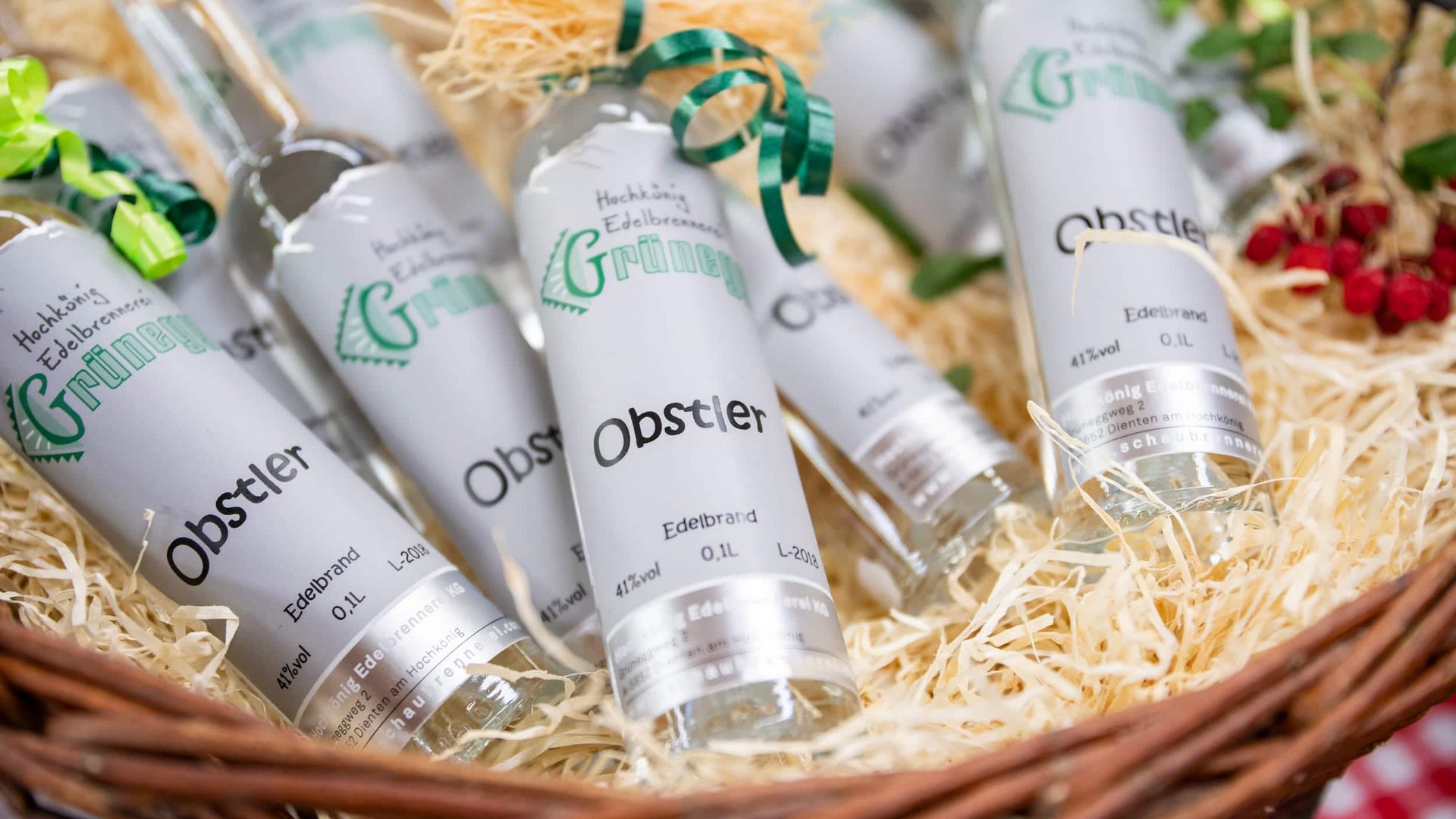 Basket with small bottles of Obstler schnapps on wood shavings