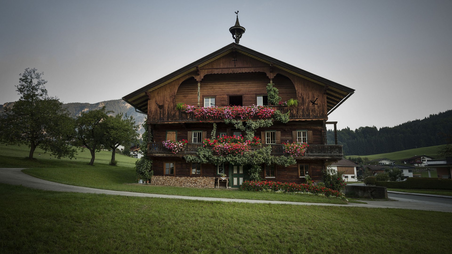 Traditional wooden house with flowers and mountains in the background