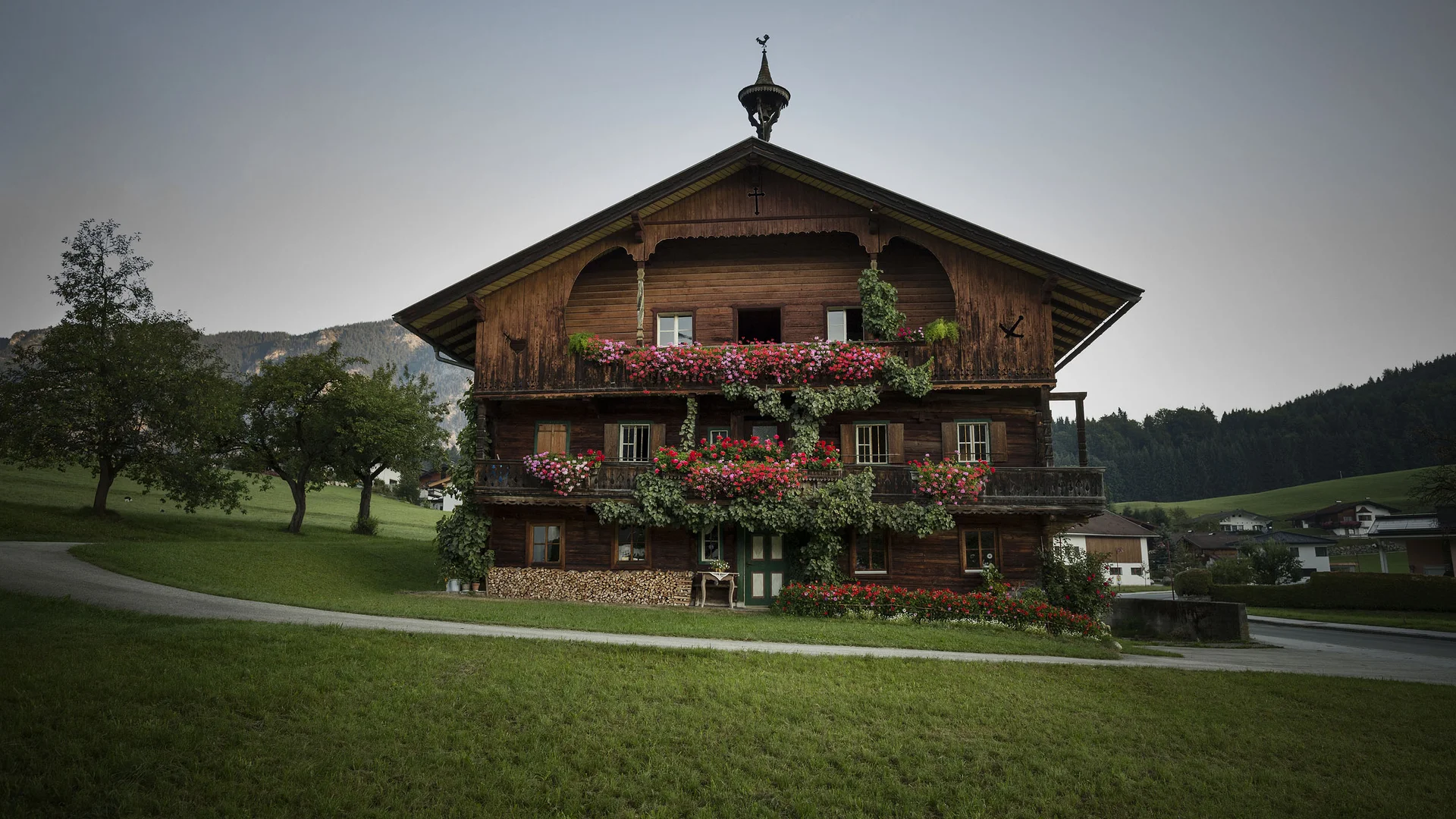 Traditionelles Holzhaus mit Blumen und Bergen im Hintergrund