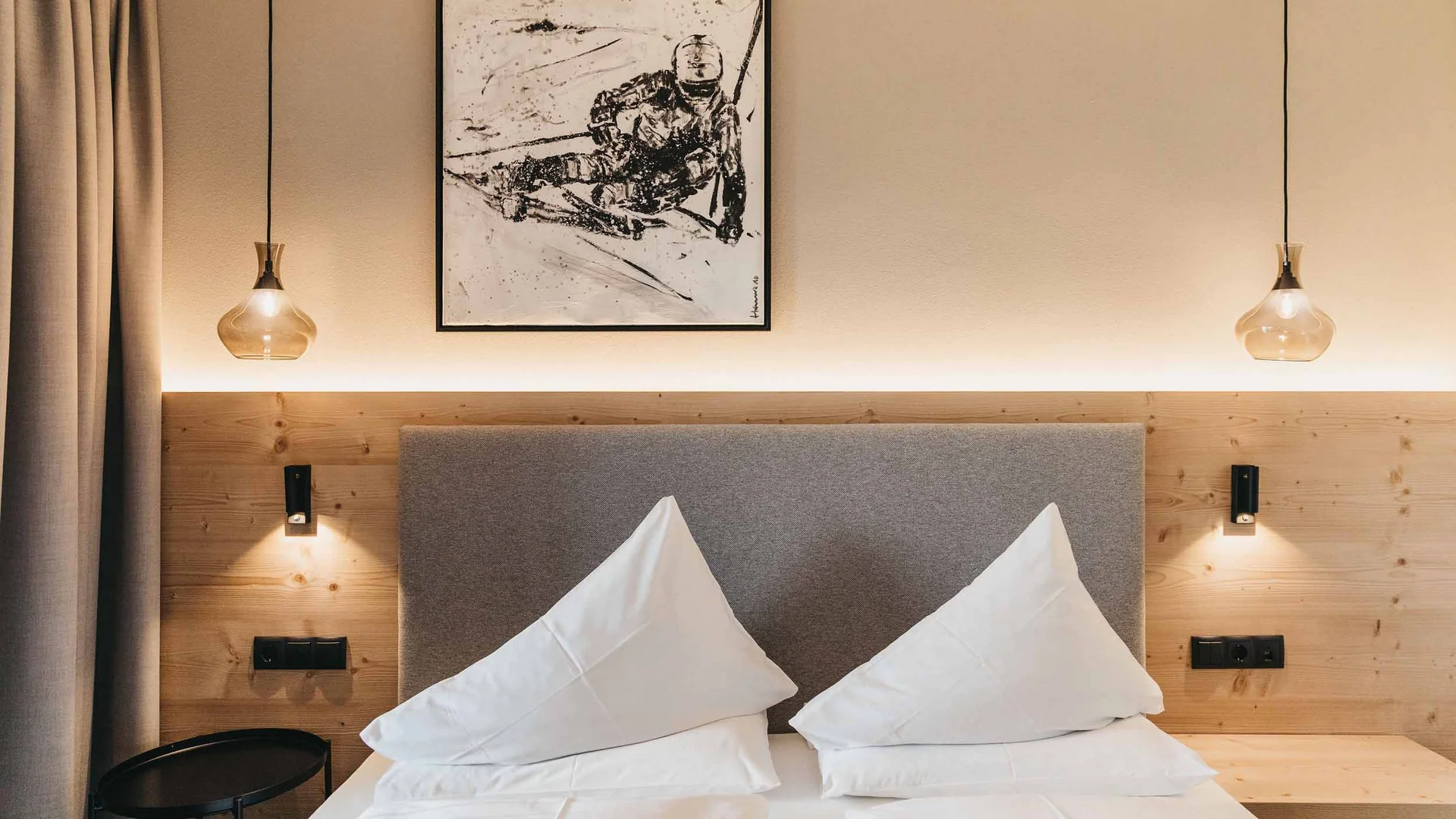 Modernes Schlafzimmer mit zwei weißen Kissen und abstraktem Bild an der Wand