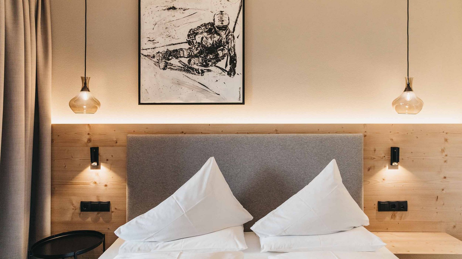 Modern bedroom with two white pillows and abstract artwork on the wall