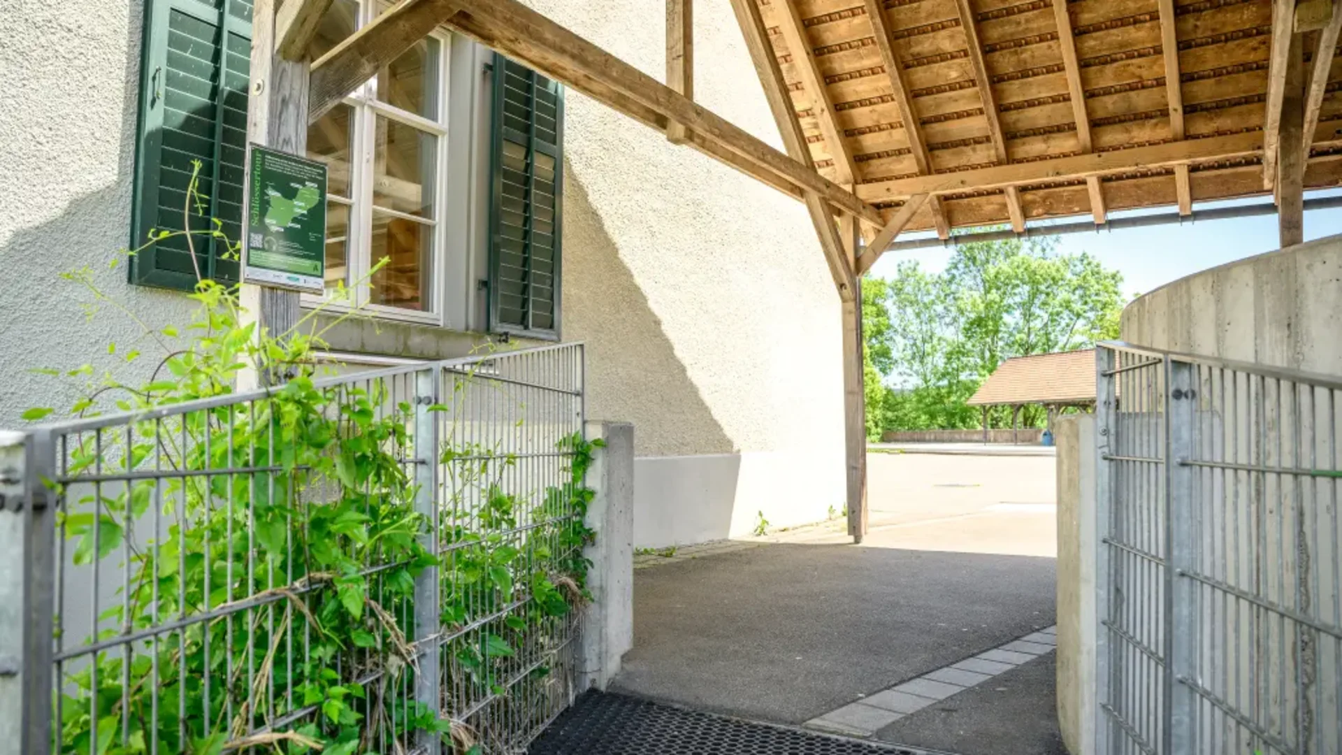 Tour-Detail © Balz Kubli Überdachter Zugang mit Fenster und grüner Pflanzen am Zaun