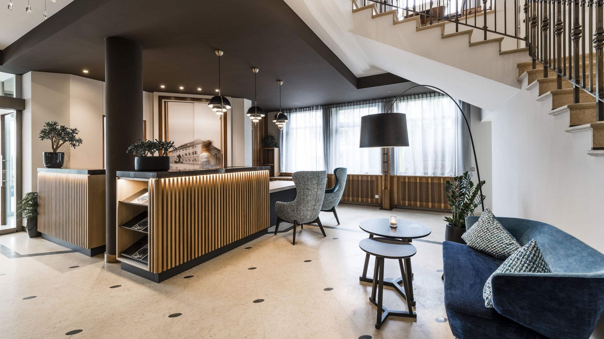 Modern hotel reception with seating area and staircase
