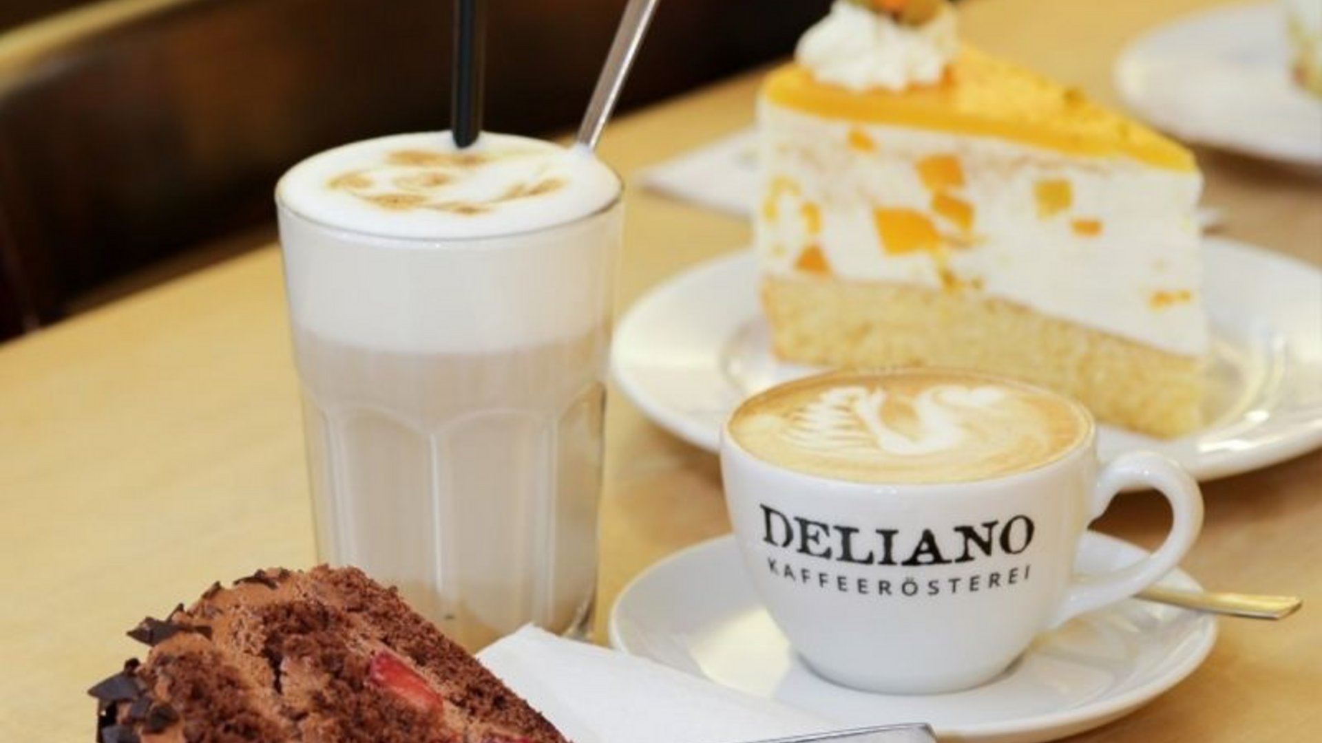 Coffee drinks and slices of cake on a café table