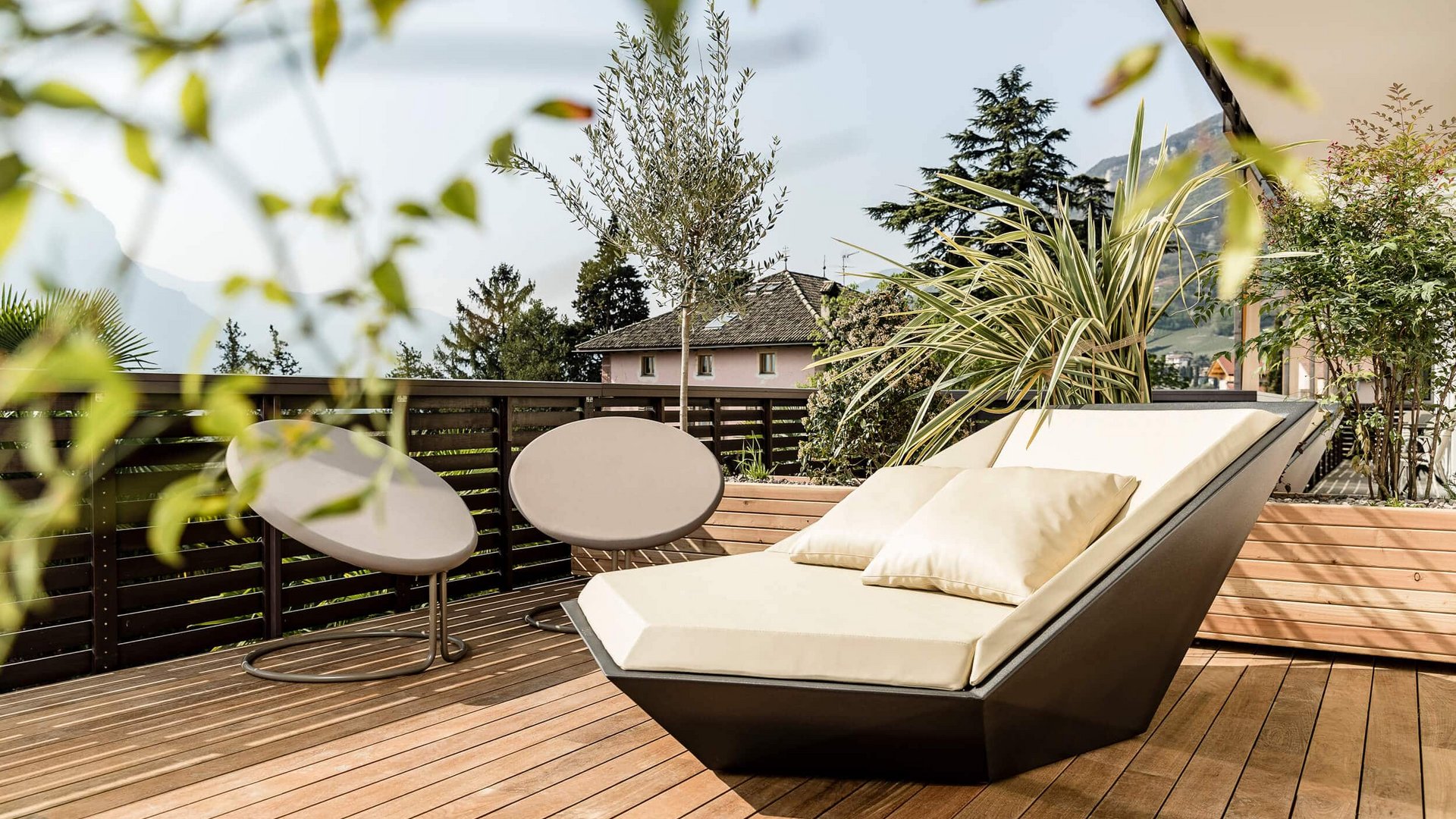 Modern outdoor seating area with stylish chairs and plants on a wooden deck