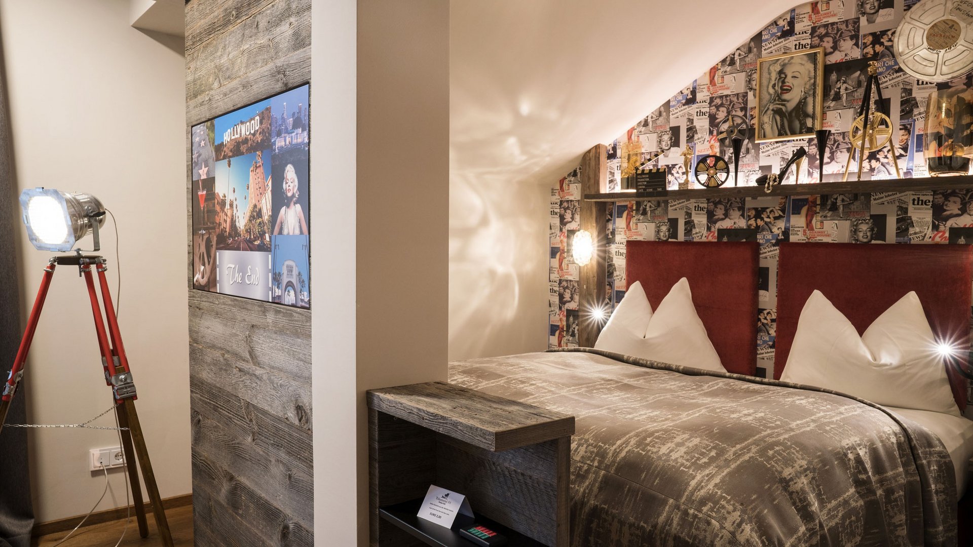 Cozy double bedroom with film-themed decor and vintage tripod lamp