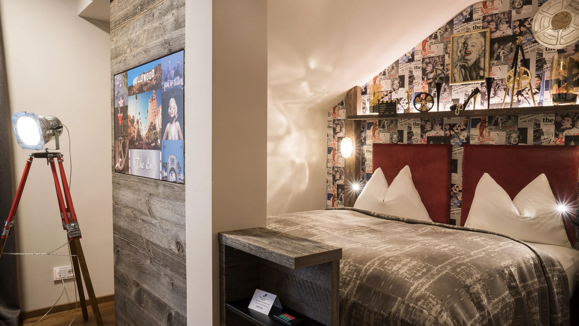Cozy double bedroom with film-themed decor and vintage tripod lamp