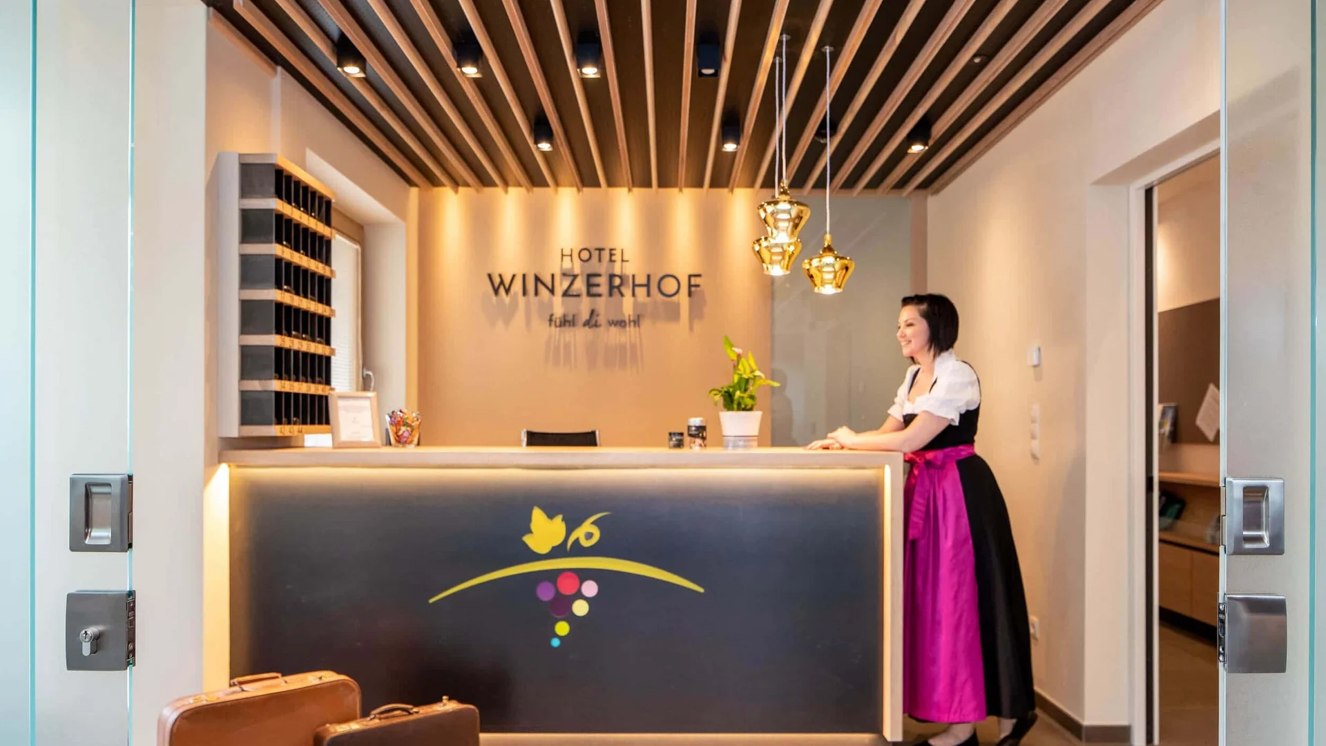 Rezeption im Hotel Winzerhof mit Angestellter in traditioneller Kleidung
