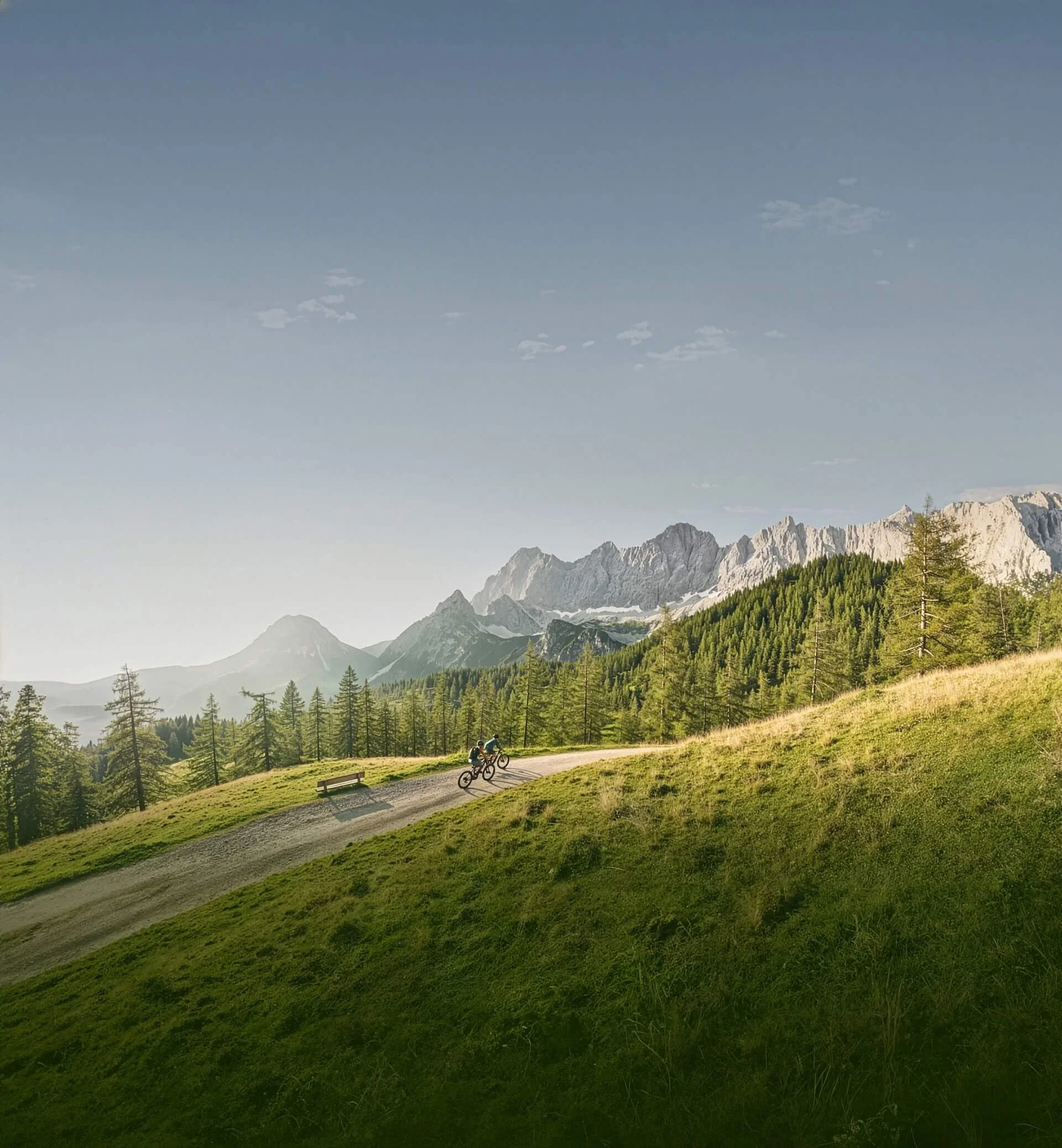 Zwei Mountainbiker auf einem Weg in den Bergen bei klarem Himmel