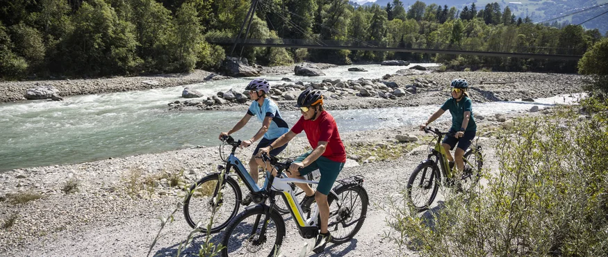 Vier Tage, vier Seiten der RheinWelten © Heiko Mandl Drei Radfahrer fahren auf einem Weg neben einem Fluss in den Bergen