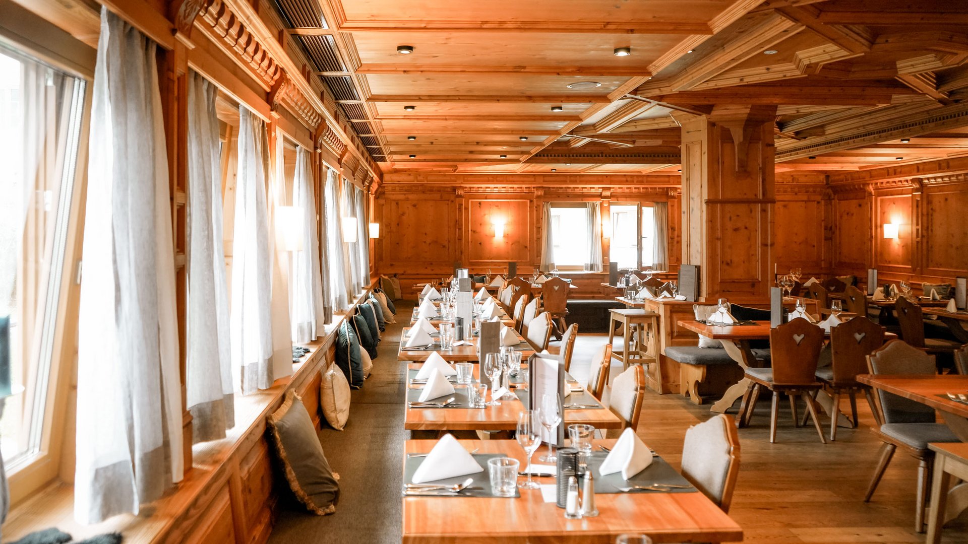 Cozy restaurant with wooden tables and table settings in warm wood decor