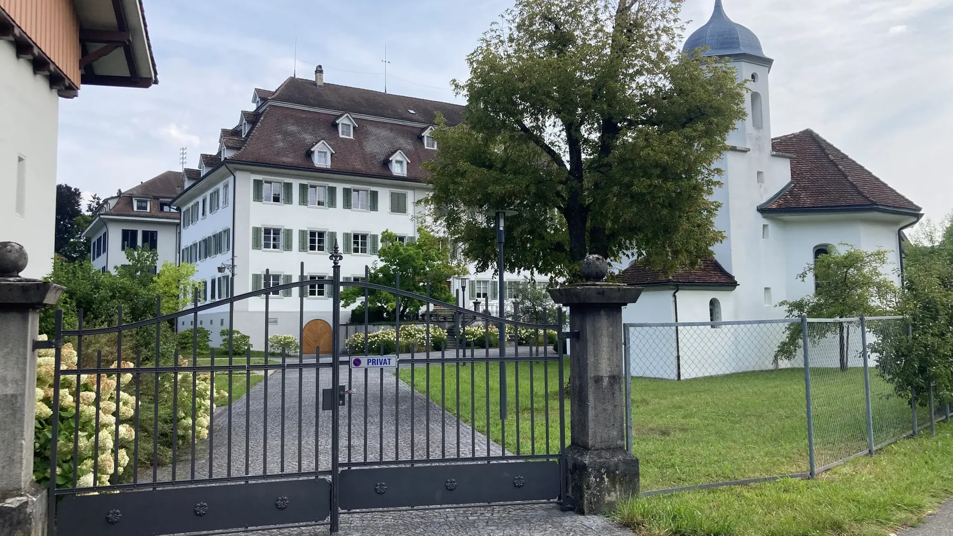 Tour detail © Thurgau Tourismus View of a closed gate in front of a historic building and church