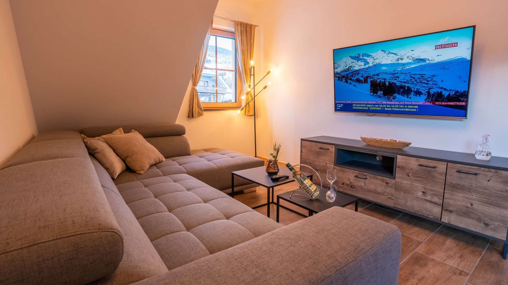 Cozy living room with gray sofa, TV, and window view