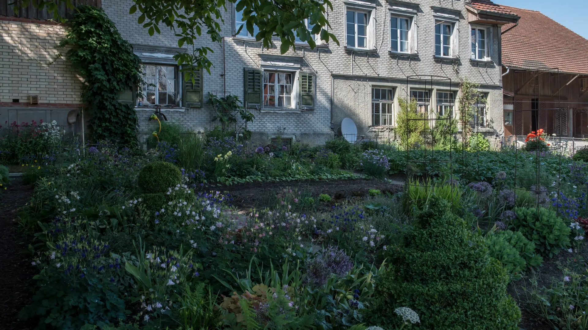 House with brick wall and flower garden in front