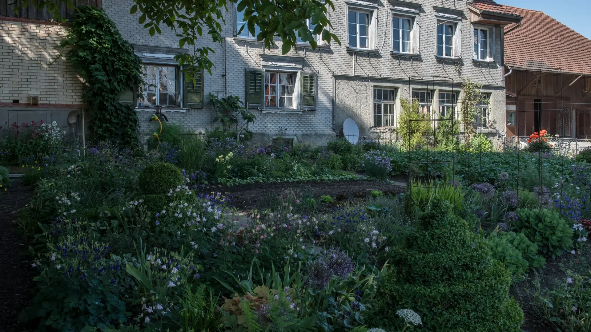 Huis met bakstenen muur en bloementuin ervoor