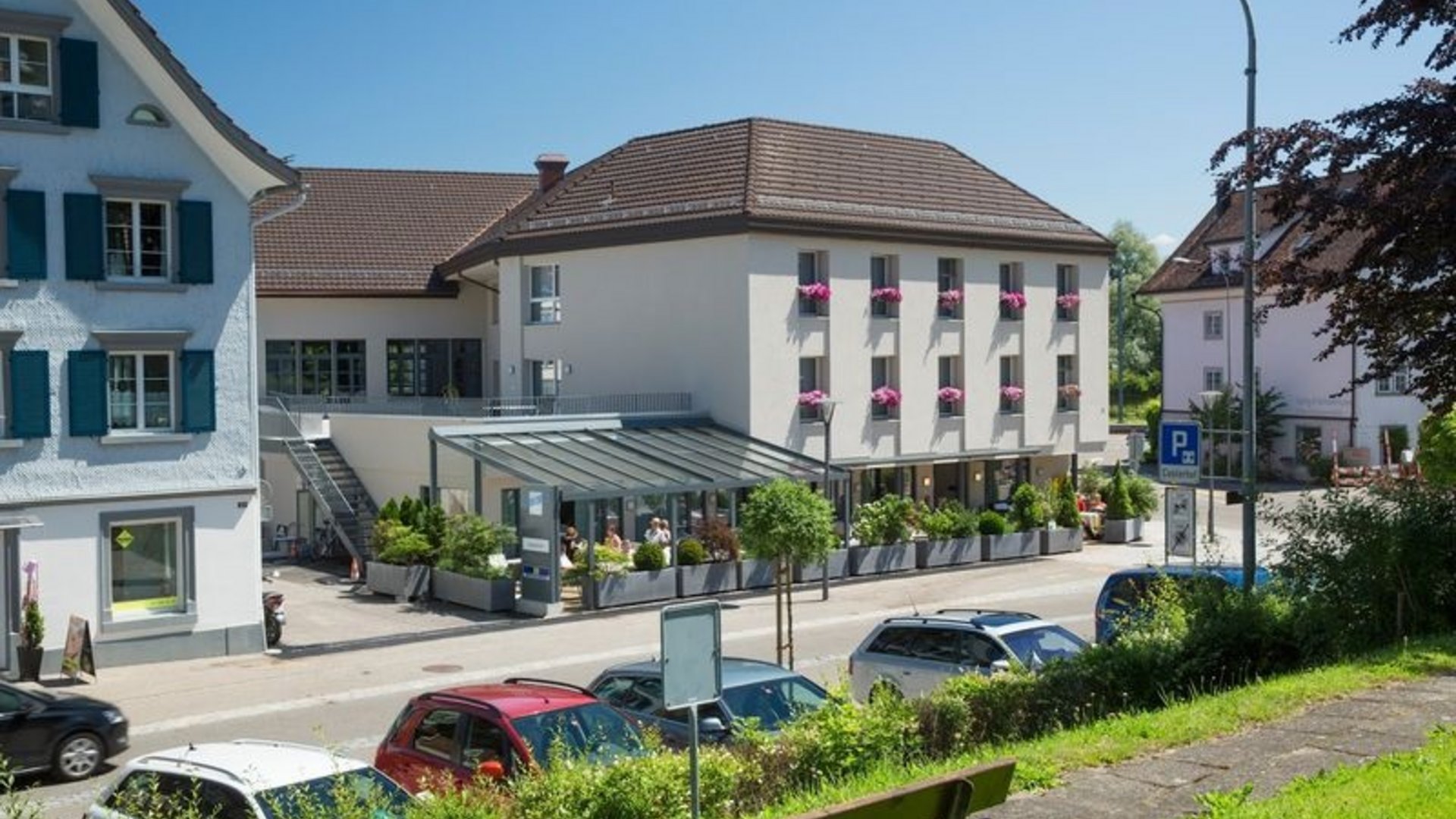 View of a busy street with houses and parked cars under clear sky