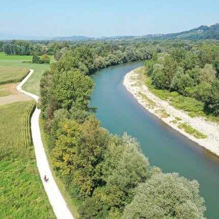 River with walking path and green fields on a sunny day