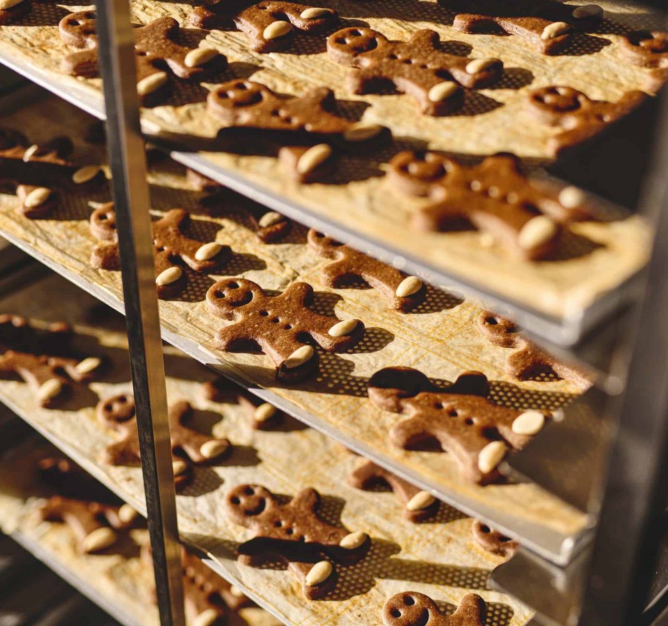 Baking trays with gingerbread men in the oven