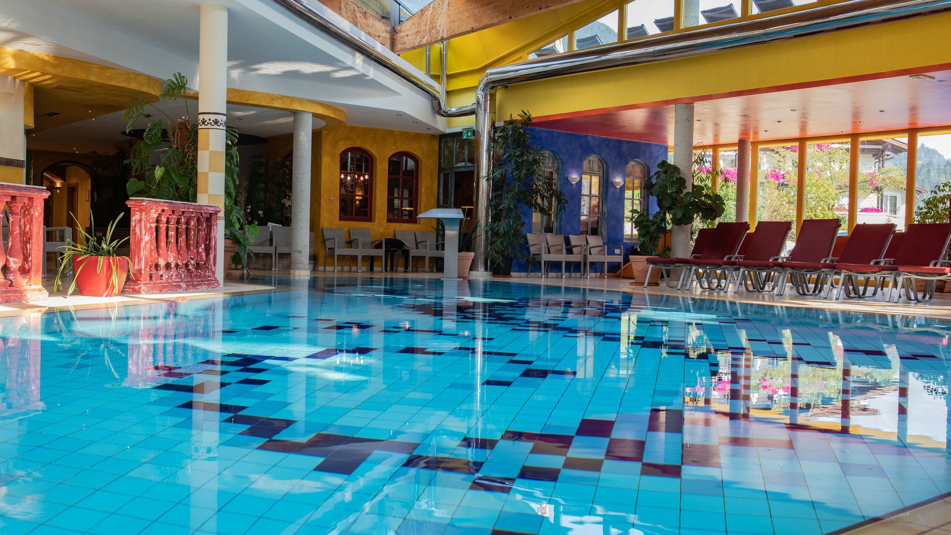Indoor pool with colorful walls and lounge chairs in a wellness area