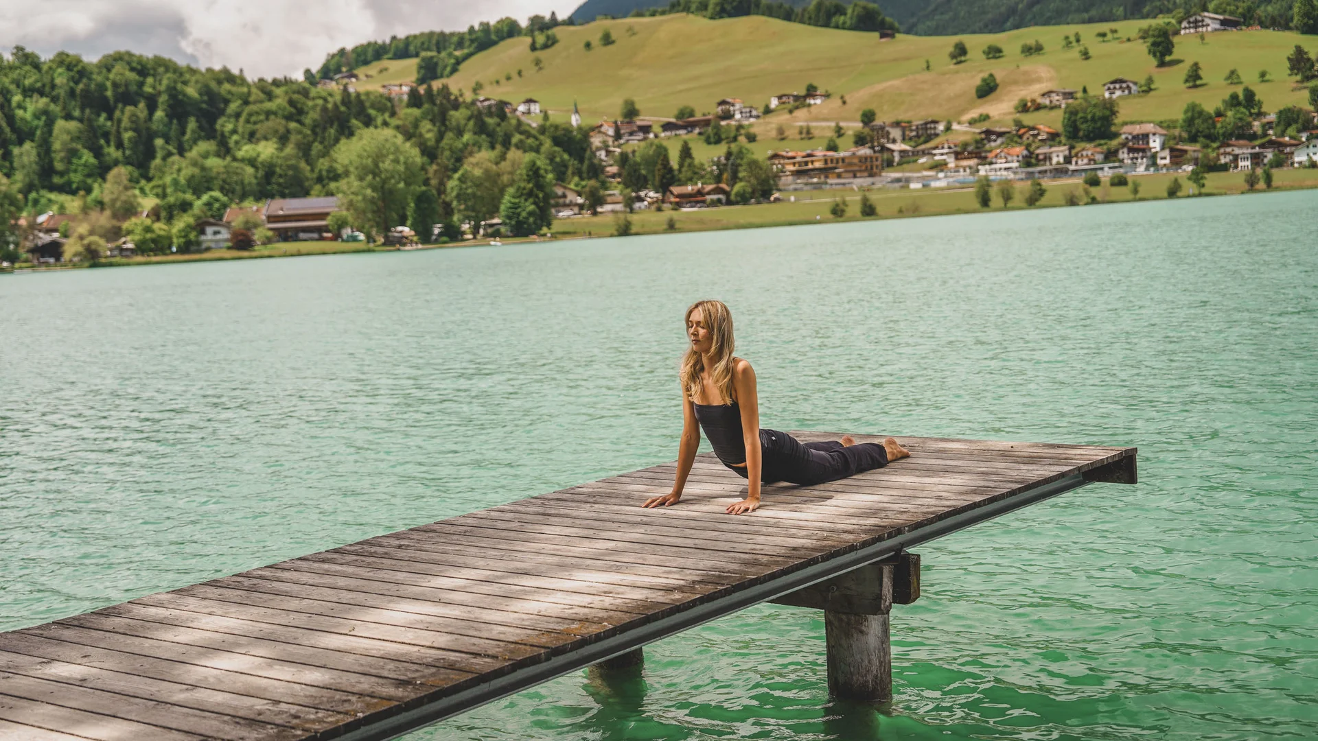 Hotel Thierseerhof **** Woman doing yoga on a pier over a lake with mountains in the background