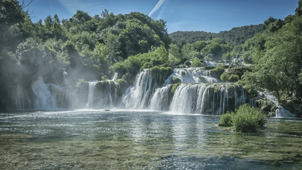 Kroatien: Entdecke das Land der 1001 Inseln mit Rad und Schiff! © Ivan Duran Wasserfall in einem grünen Wald unter blauem Himmel