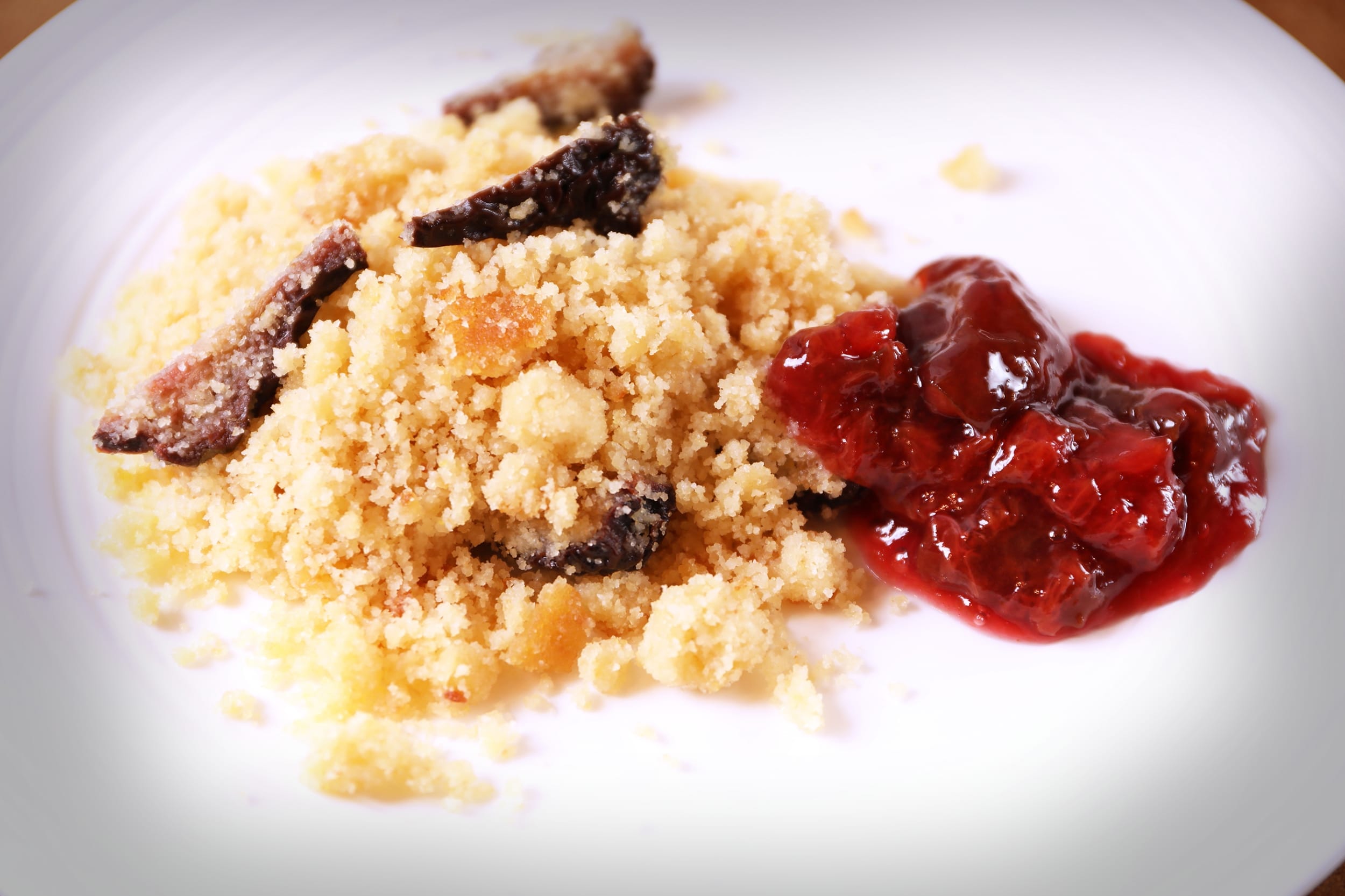 Crumble cake with fruit jam on white plate
