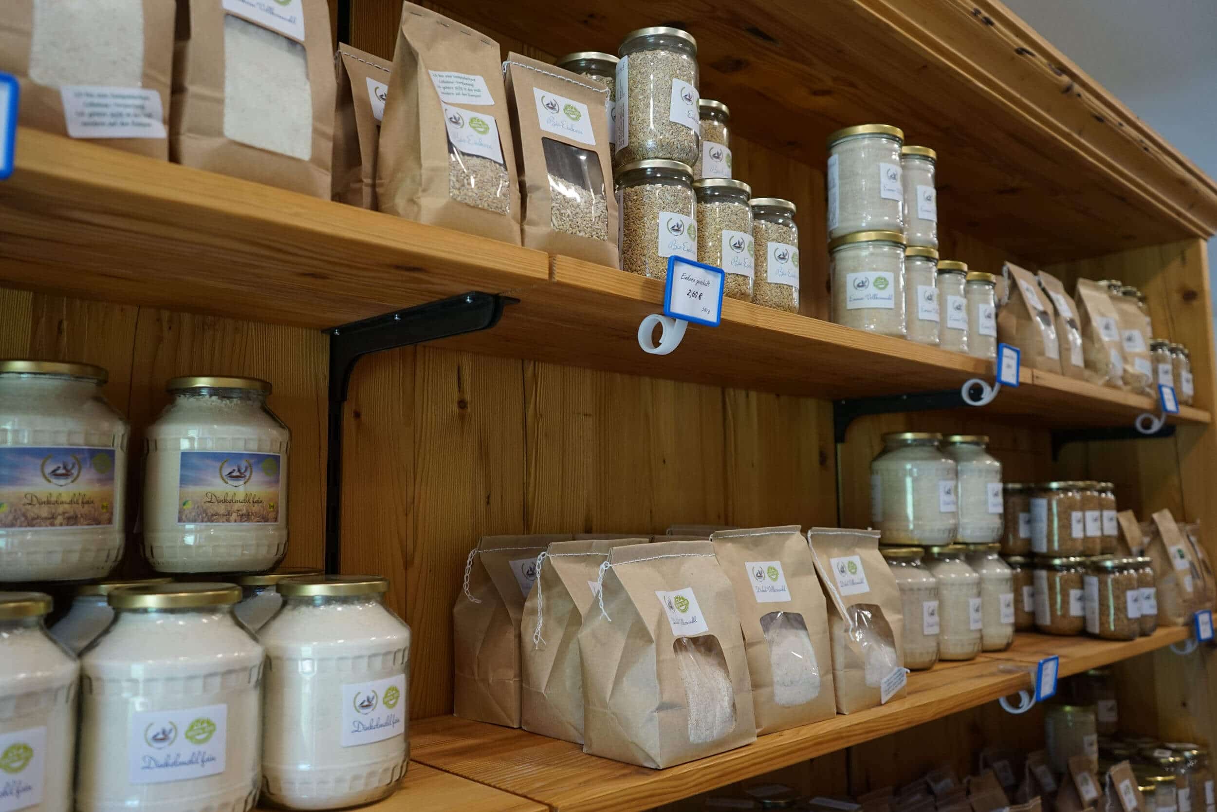 Shelf with glass jars and paper bags of grains and flour