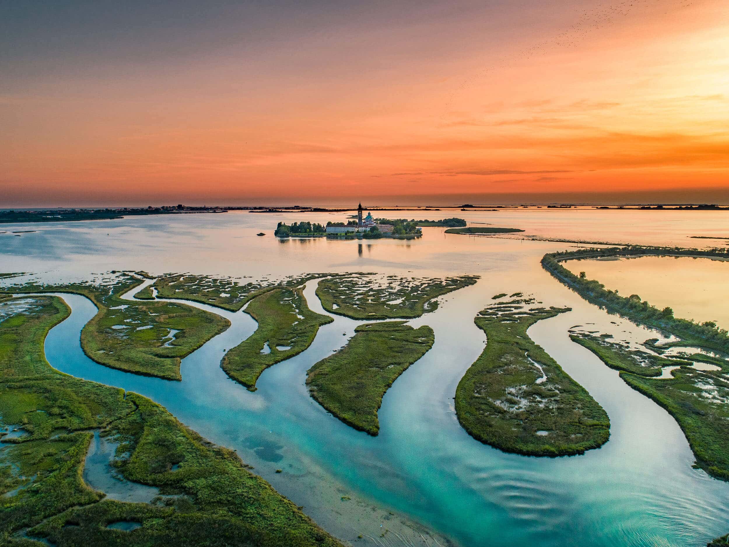 Landschaft mit Insel und Flussarmen bei Sonnenuntergang