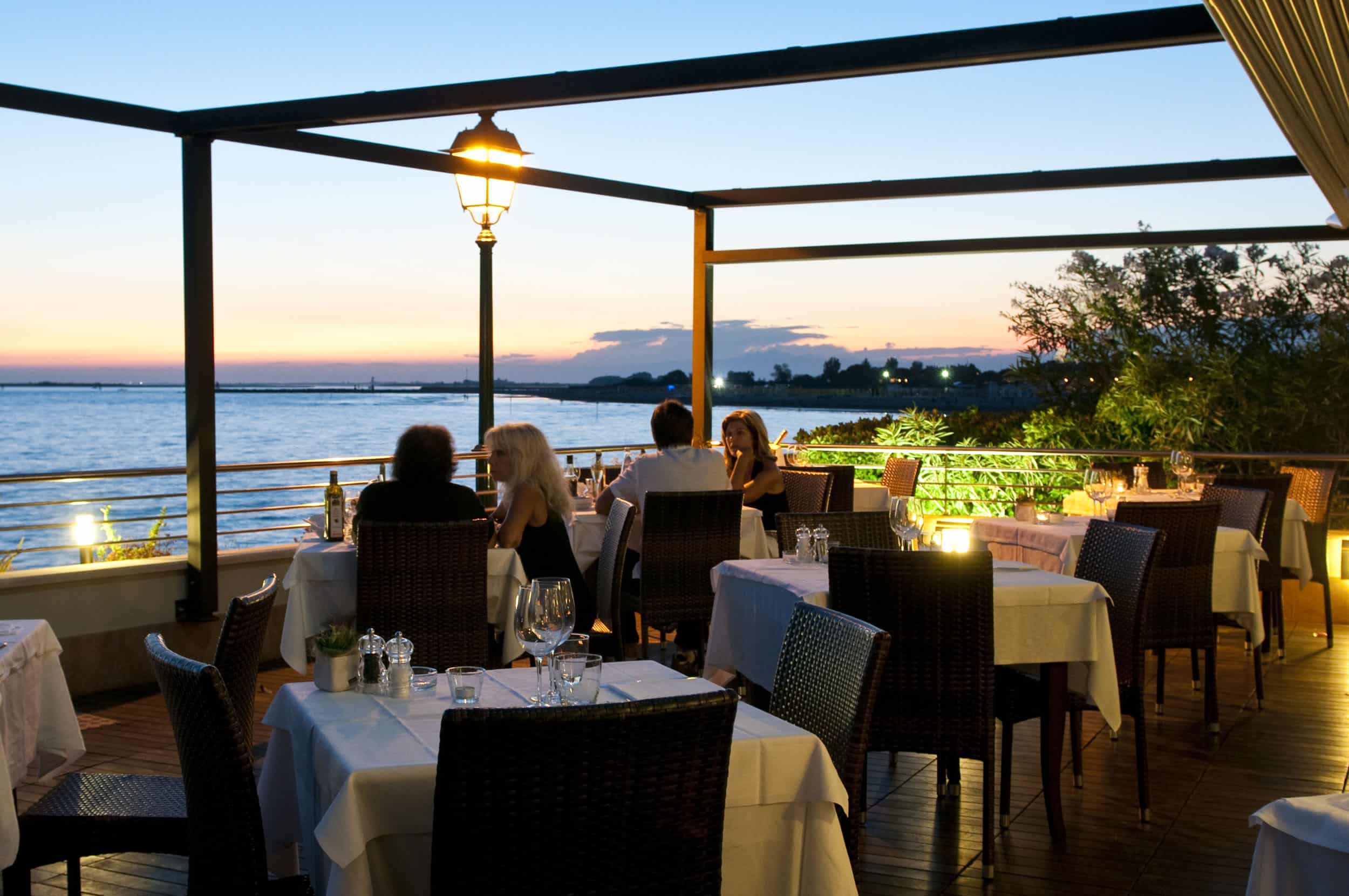 Abendessen im Freien mit Blick auf das Meer bei Sonnenuntergang