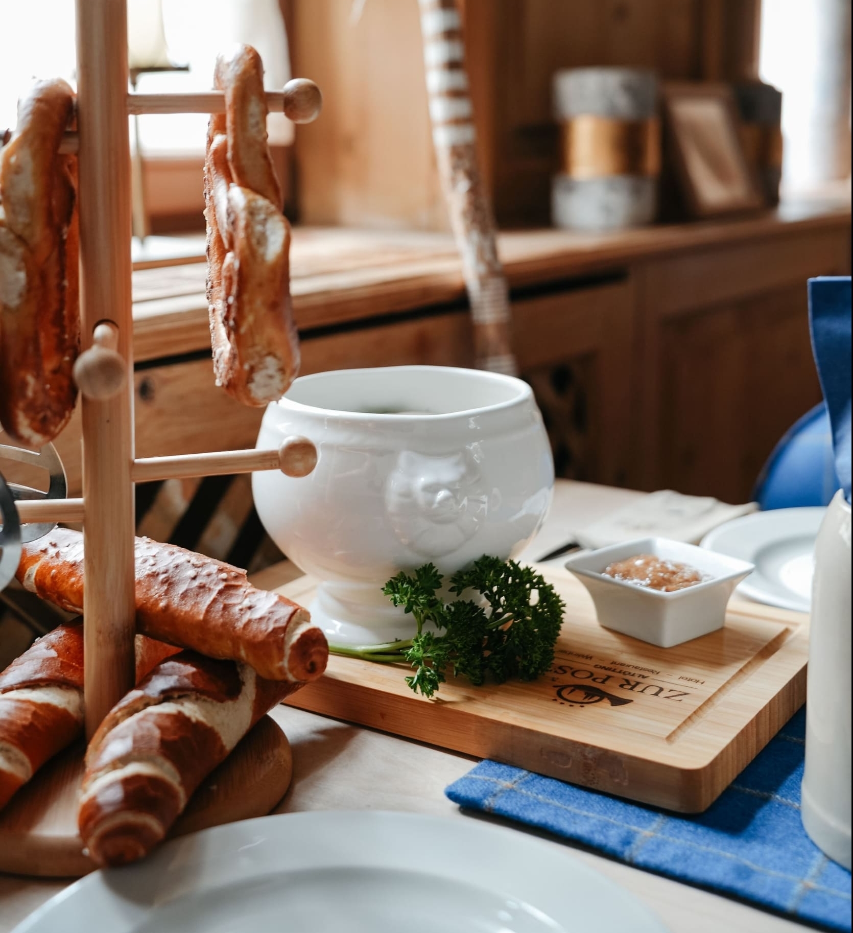 Bread and white wine fondue on wooden table with herbs and dip