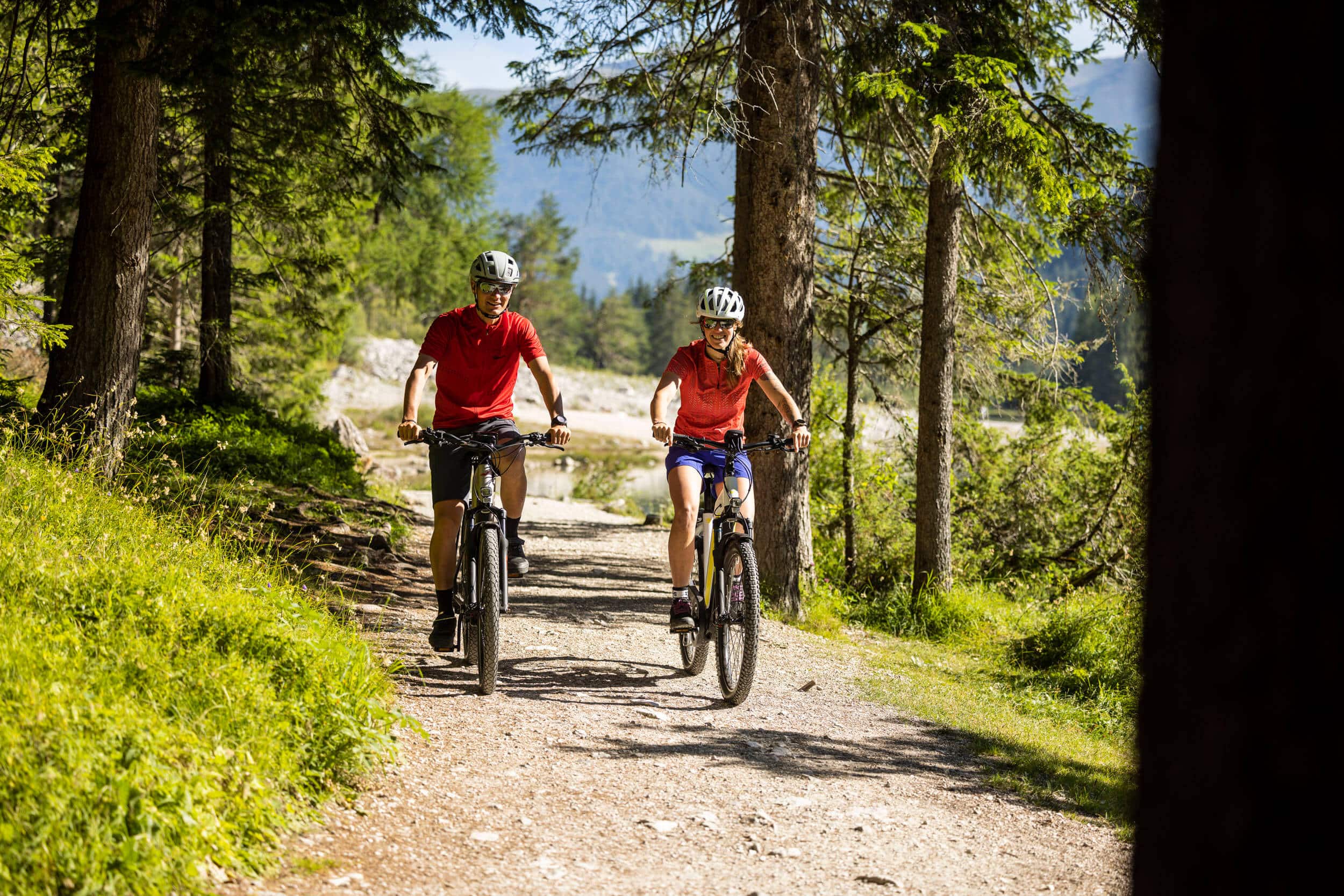Packliste für einen perfekten Radurlaub © Velontour Zwei Radfahrer fahren auf einem Waldweg an einem sonnigen Tag