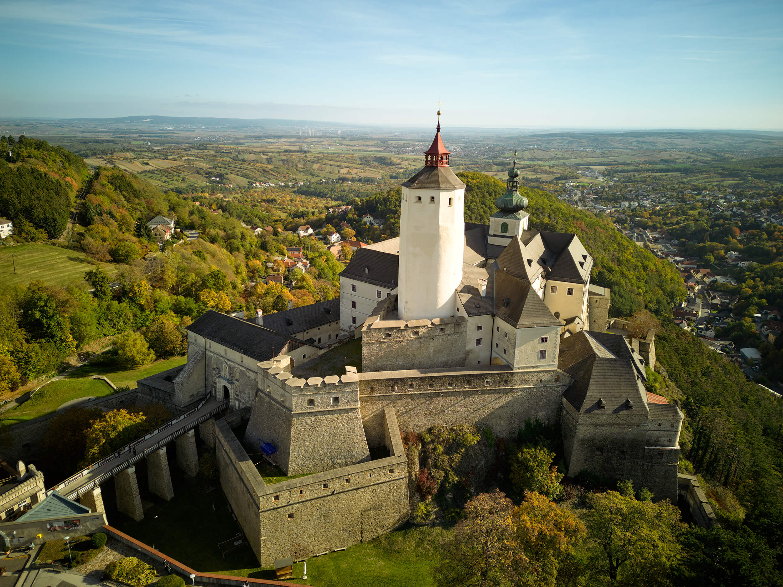 Luftaufnahme der Burg Kreuzenstein mit umliegender Herbstlandschaft