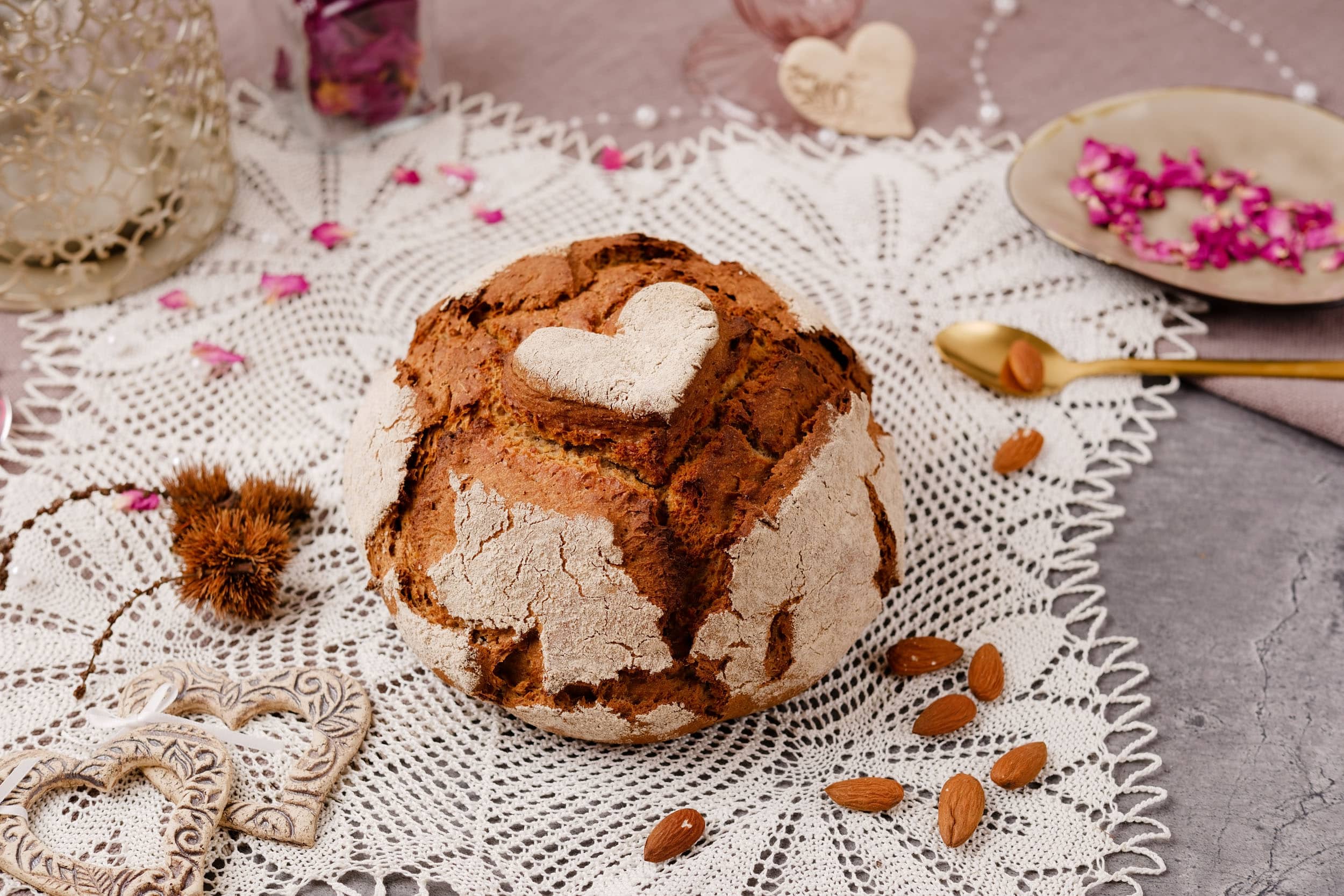 Round bread with heart shape on a crocheted lace doily