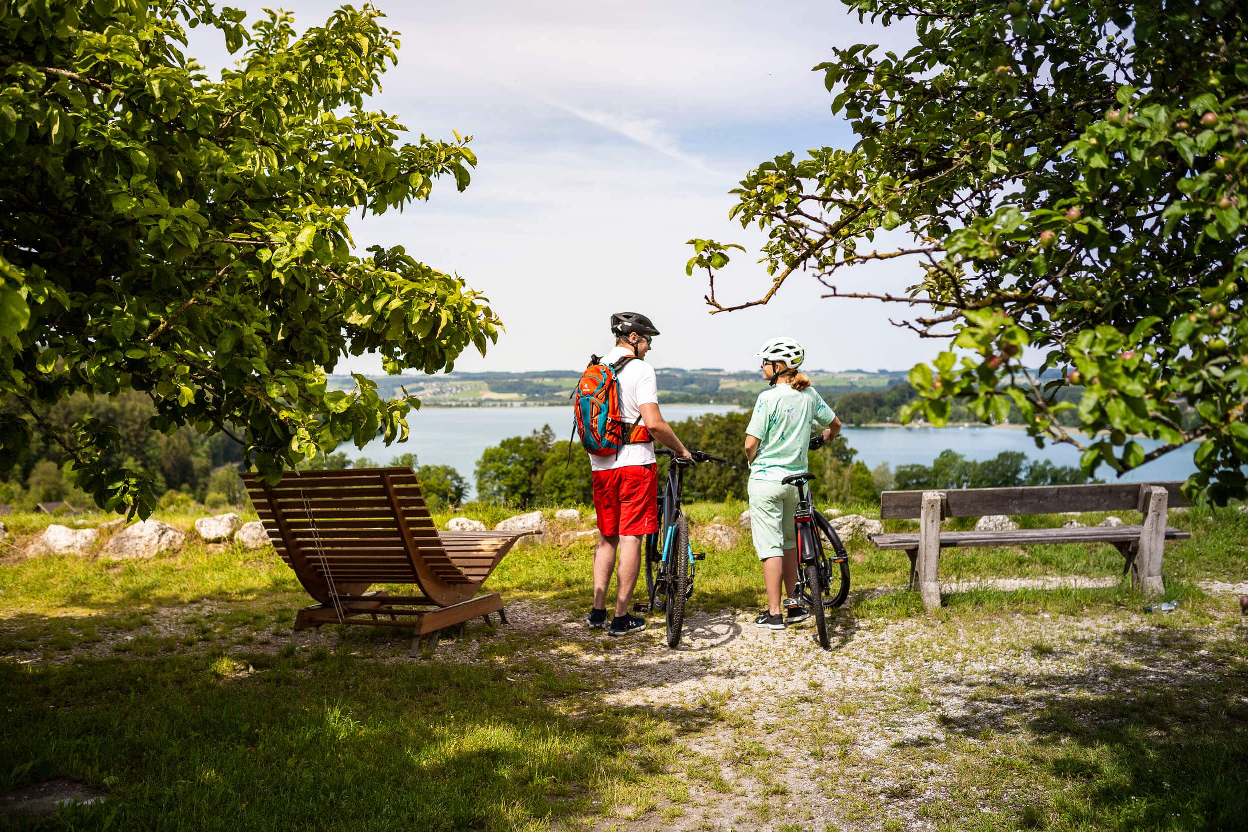 Zwei Radfahrer mit Blick auf See in grüner Landschaft