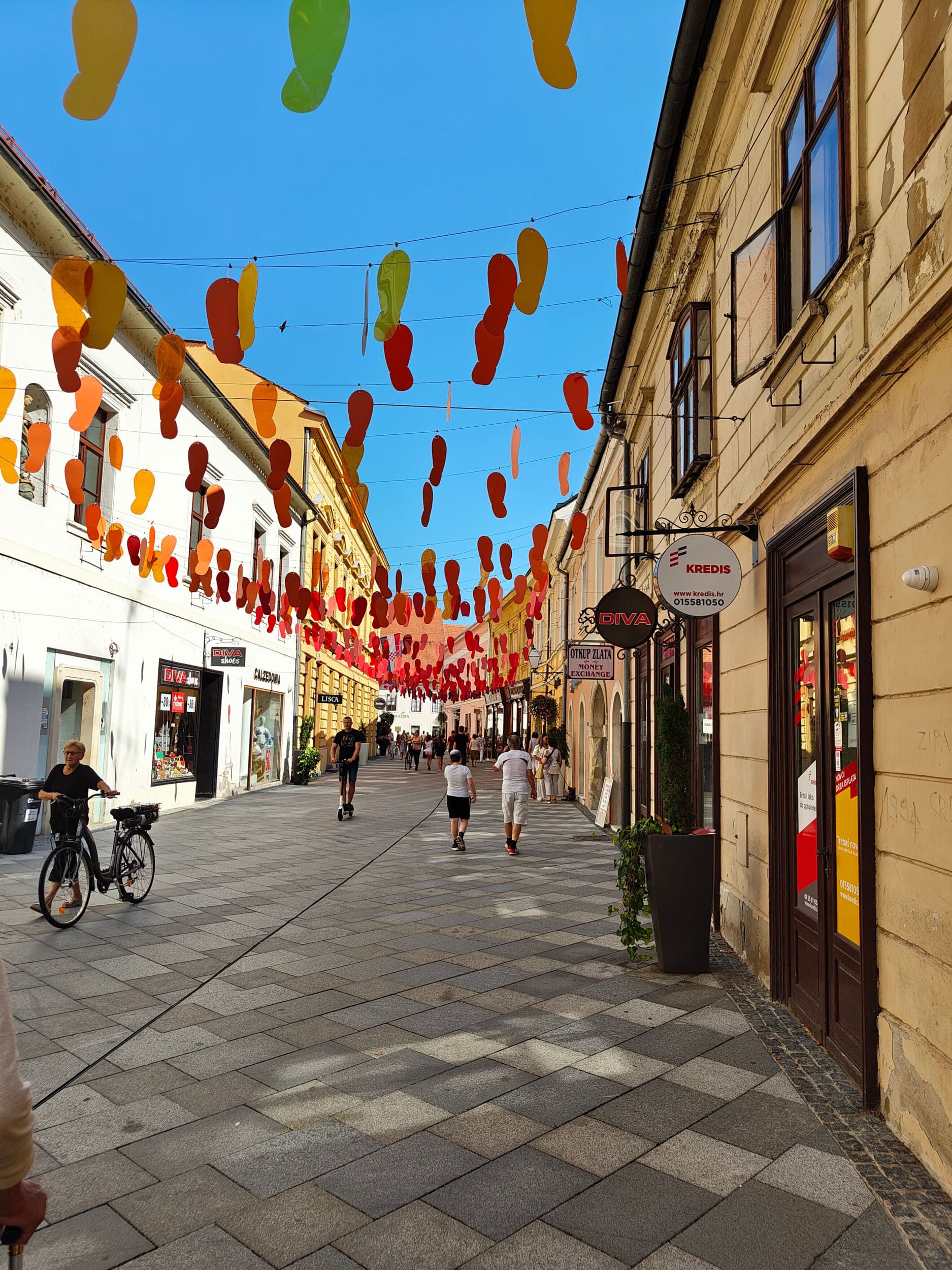 Der Drauradweg: Ein Geheimtipp für Genussradler © Drauradweg Wirte - Claudia Tscherne Belebte Fußgängerstraße mit hängenden bunten Dekorationen über Kopf