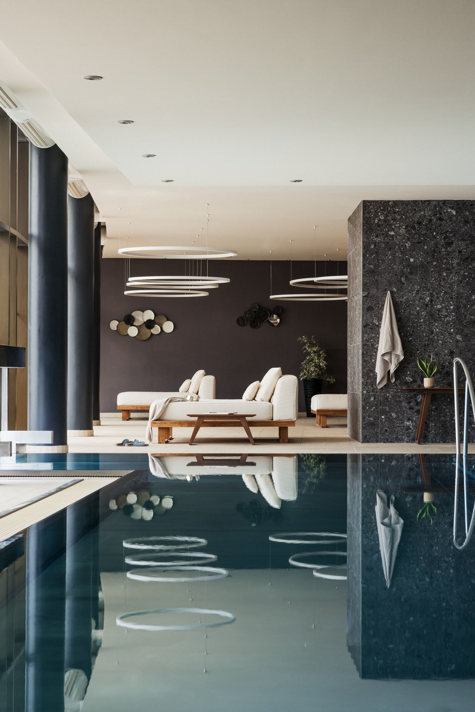 Moderner Innenpool mit Liegen und dekorativer Wandgestaltung