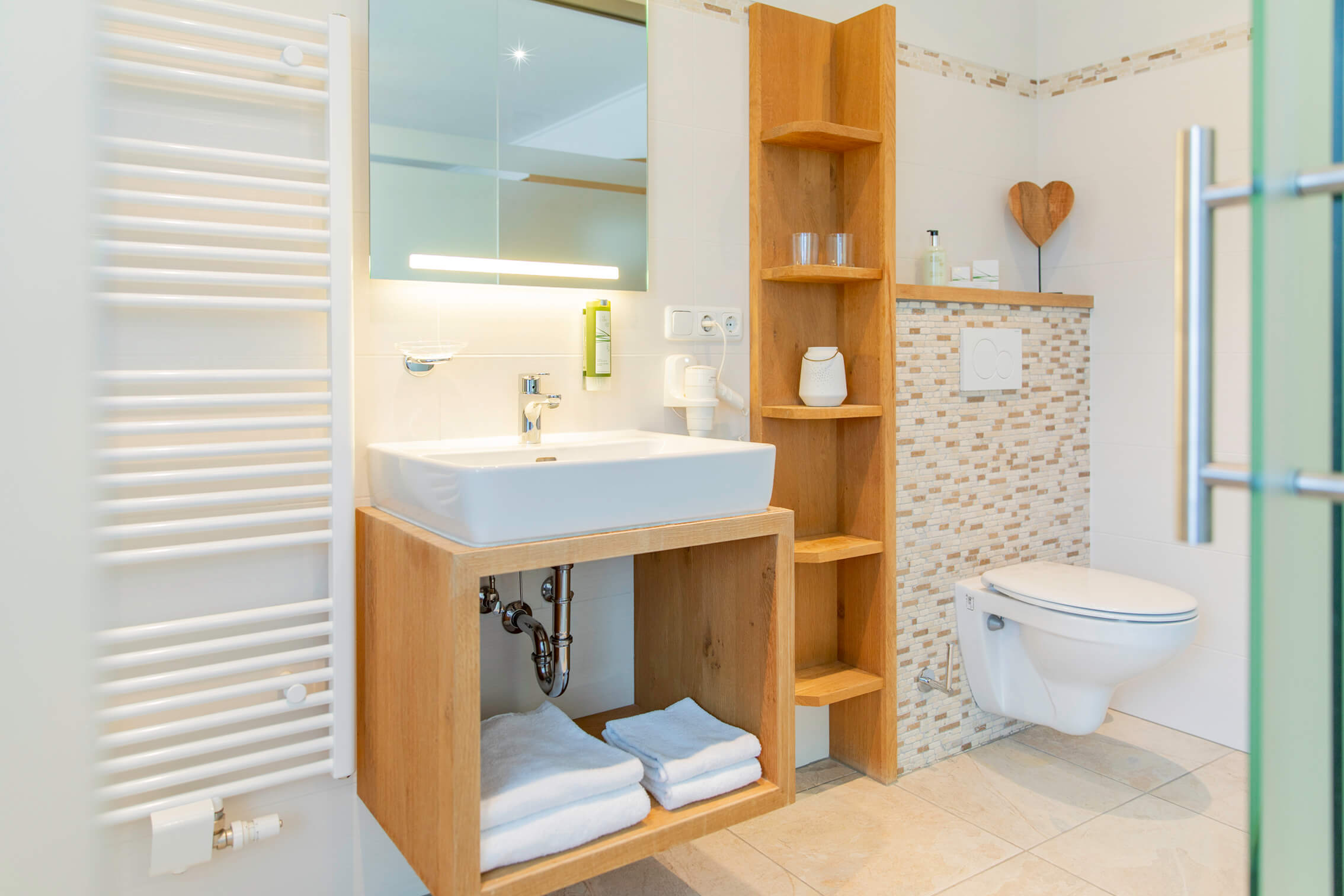 Packliste für einen perfekten Radurlaub © Isabella Anker Modernes Badezimmer mit Holzregal, Waschbecken und Wandtoilette