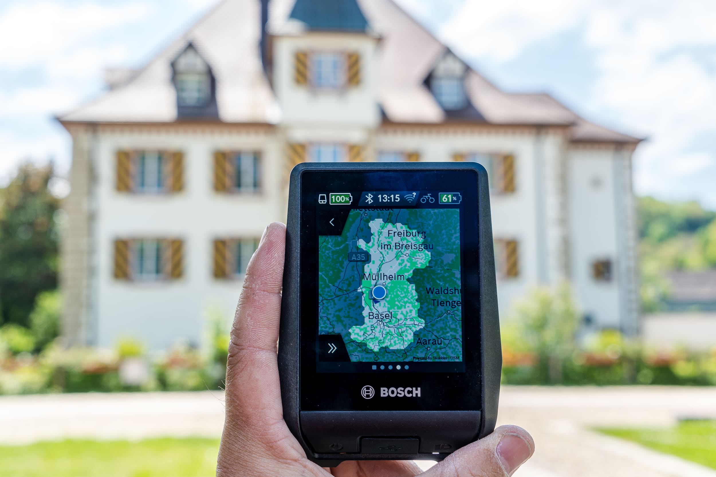 Hand hält Bosch Navigationsgerät mit Karte von Basel und Umgebung