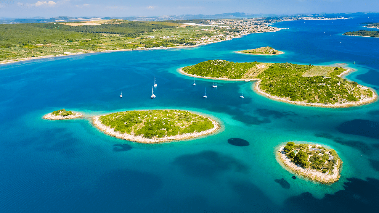 Luftaufnahme von Inseln und blauem Wasser mit Segelbooten an der Küste