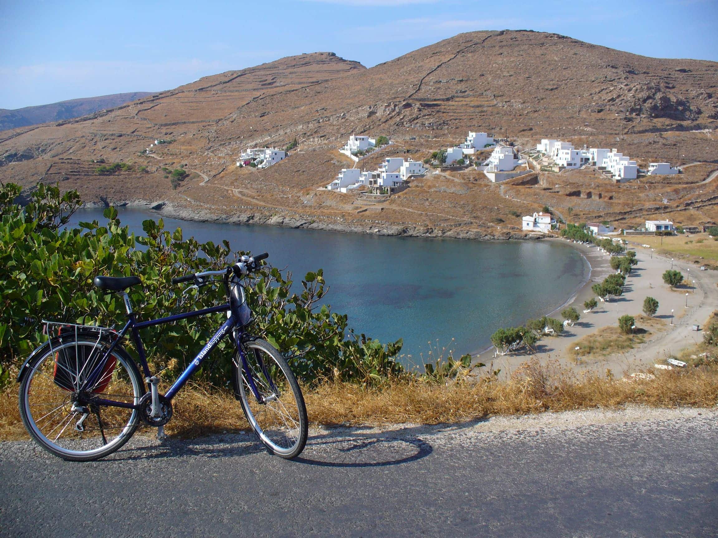 Fahrrad an Bergstraße mit Blick auf Bucht und weiße Häuser am Hügel
