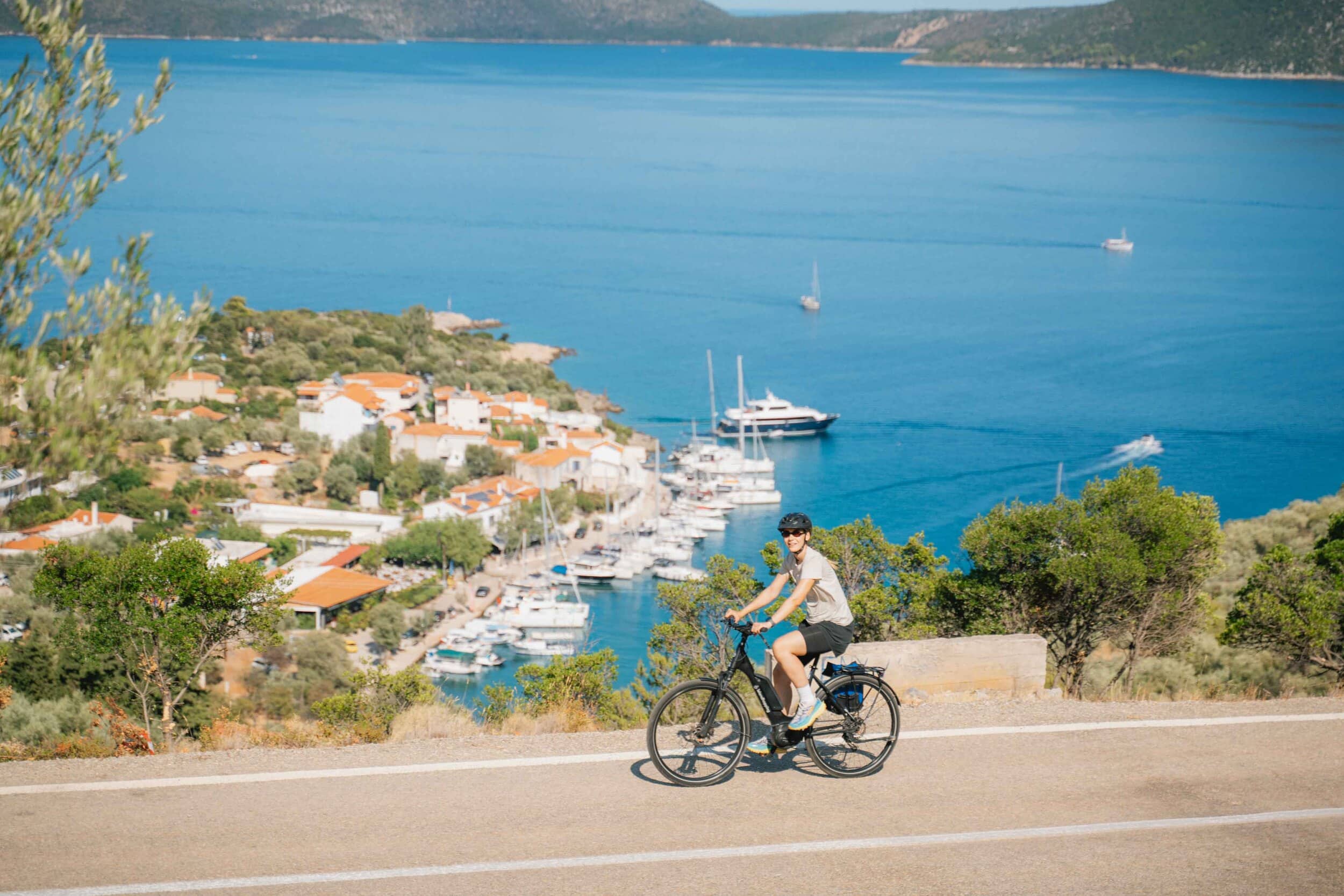 Fahrradfahrer auf einer Straße mit Blick auf das Meer und Hafen
