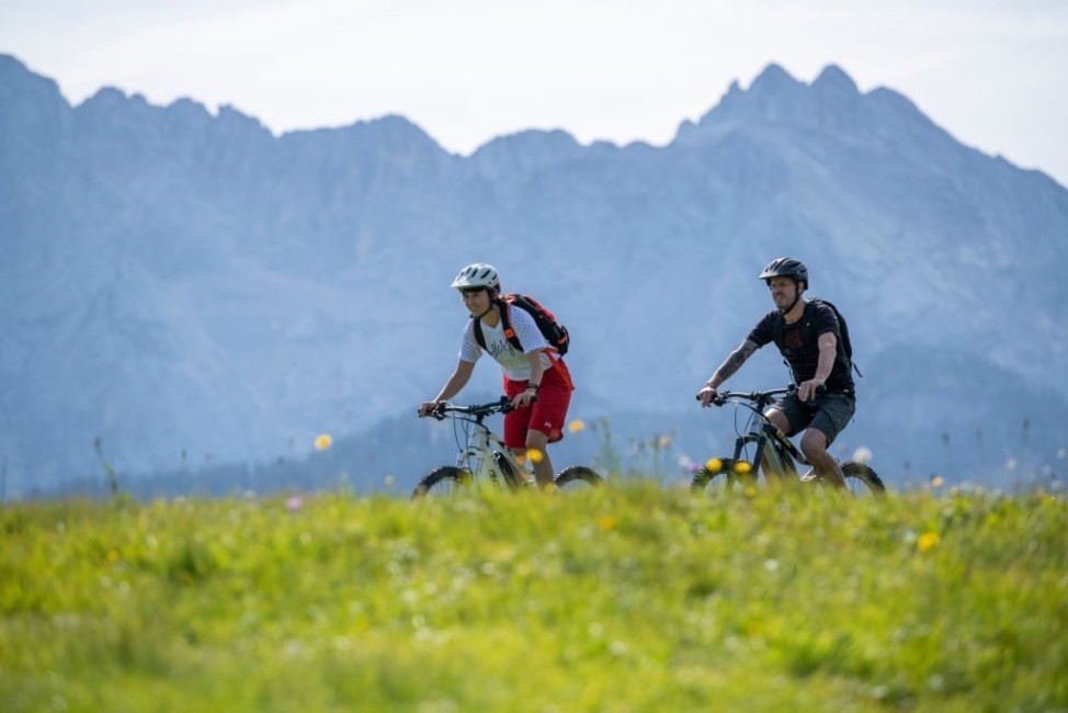 Paar mit E-Bikes vor Gebirge © GaPa Tourismus GmbH - Christian Stadler
